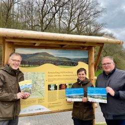 Uwe Müller hält das neue Faltblatt, Claudia Wilhelm und Martin Kozber die Förderplakette in den Händen
